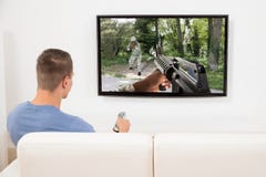 Hombre que juega al juego de ordenador en la televisión fotos de archivo libres de regalías Hombre que juega al juego de ordenador en la televisión fotos de archivo libres de regalías