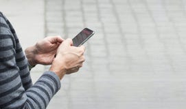 Hombre que manda un SMS en el pavimento del parque de la ciudad abierta foto de archivo libre de regalías Hombre que manda un SMS en el pavimento del parque de la ciudad abierta foto de archivo libre de regalías