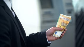 Hombre que sostiene billetes de banco euro retirados del cajero automático, buen servicio, viaje de negocios imagen de archivo Hombre que sostiene billetes de banco euro retirados del cajero automático, buen servicio, viaje de negocios imagen de archivo