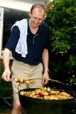 Hombre que tiende la barbacoa Hombre que tiende la barbacoa
