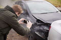 Hombre que toma la foto del accidente de tráfico en el teléfono móvil fotografía de archivo libre de regalías Hombre que toma la foto del accidente de tráfico en el teléfono móvil fotografía de archivo libre de regalías