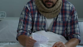 Hombre que tose enfermo en la instrucción de las píldoras de la lectura de la cama, síntoma de la gripe, atención sanitaria metrajes Hombre que tose enfermo en la instrucción de las píldoras de la lectura de la cama, síntoma de la gripe, atención sanitaria metrajes