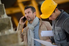 Hombre que usa el teléfono fuera de la fábrica Imagen de archivo libre de regalías Hombre que usa el teléfono fuera de la fábrica Imagen de archivo libre de regalías