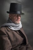 Hombre siniestro que lleva un sombrero de copa y una bufanda gris fotos de archivo libres de regalías Hombre siniestro que lleva un sombrero de copa y una bufanda gris fotos de archivo libres de regalías