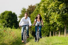 Hombre y mujer que completan un ciclo en verano imagen de archivo libre de regalías Hombre y mujer que completan un ciclo en verano imagen de archivo libre de regalías