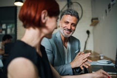 Hombre y mujer que tienen reunión de negocios en un café, usando el ordenador portátil foto de archivo libre de regalías Hombre y mujer que tienen reunión de negocios en un café, usando el ordenador portátil foto de archivo libre de regalías