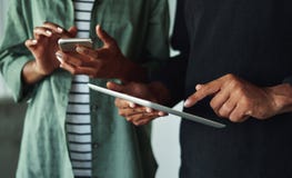Hombre y mujer que usa la tableta y el smartphone digitales imagen de archivo Hombre y mujer que usa la tableta y el smartphone digitales imagen de archivo