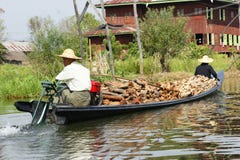 Hombres con madera en el barco en el lago Inle en Birmania, Asia imagen de archivo Hombres con madera en el barco en el lago Inle en Birmania, Asia imagen de archivo