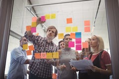 Hombres de negocios que planean con las notas adhesivas en oficina creativa imagenes de archivo Hombres de negocios que planean con las notas adhesivas en oficina creativa imagenes de archivo