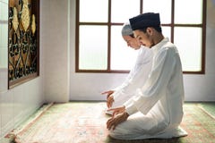 Hombres musulmanes que ruegan en la postura de Tashahhud imagenes de archivo Hombres musulmanes que ruegan en la postura de Tashahhud imagenes de archivo