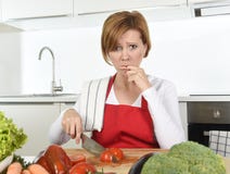 Home cook woman in red apron slicing carrot with kitchen knife suffering domestic accident cutting hurting finger Royalty Free Stock Image Home cook woman in red apron slicing carrot with kitchen knife suffering domestic accident cutting hurting finger Royalty Free Stock Image