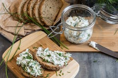 Home made bread on a wooden cutting board with curd cheese and ricotta and herbs. Decorated with green herbs royalty free stock photo Home made bread on a wooden cutting board with curd cheese and ricotta and herbs. Decorated with green herbs royalty free stock photo
