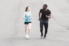 Homem afro-americano dos pares novos felizes e mulher europeia que correm junto Um par de amor é corrido, contratado nos esportes fotografia de stock royalty free Homem afro-americano dos pares novos felizes e mulher europeia que correm junto Um par de amor é corrido, contratado nos esportes fotografia de stock royalty free