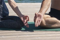 Homem atrativo e ioga praticando fêmea no fim da pose dos lótus acima das mãos Um par novo que faz a ioga para meditar seus corpo fotos de stock royalty free Homem atrativo e ioga praticando fêmea no fim da pose dos lótus acima das mãos Um par novo que faz a ioga para meditar seus corpo fotos de stock royalty free