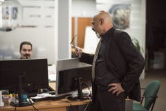 Homem calvo superior que trabalha no escritório com terno preto fotografia de stock Homem calvo superior que trabalha no escritório com terno preto fotografia de stock