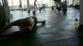 Homem cansado que encontra-se no assoalho após a sessão de formação intensa Homem cansado que encontra-se no assoalho após a sessão de formação intensa