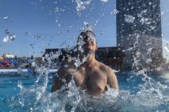 Homem caucasiano considerável que espirra na piscina fotografia de stock Homem caucasiano considerável que espirra na piscina fotografia de stock