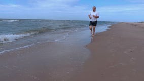Homem com corredor descalço ao longo do mar video estoque Homem com corredor descalço ao longo do mar video estoque