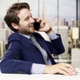 Homem de negócio feliz no telefone no escritório na cidade imagens de stock royalty free Homem de negócio feliz no telefone no escritório na cidade imagens de stock royalty free