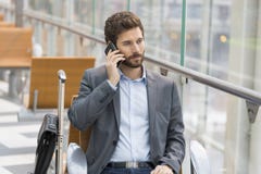 Homem de negócio ocasional no telefone celular no aeroporto do salão plano de espera imagens de stock royalty free Homem de negócio ocasional no telefone celular no aeroporto do salão plano de espera imagens de stock royalty free