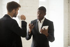 Homem de negócios afro-americano que discute o app novo com o p caucasiano imagens de stock royalty free Homem de negócios afro-americano que discute o app novo com o p caucasiano imagens de stock royalty free