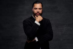 Homem de negócios afro-americano seguro em um revestimento clássico preto, pensando sobre o negócio ao guardar a mão no queixo fotografia de stock Homem de negócios afro-americano seguro em um revestimento clássico preto, pensando sobre o negócio ao guardar a mão no queixo fotografia de stock