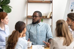 Homem de neg?cios masculino milenar nos vidros que fala ao colega no escrit?rio imagem de stock Homem de neg?cios masculino milenar nos vidros que fala ao colega no escrit?rio imagem de stock