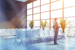 Homem de negócios na sala de espera cinzenta do aeroporto fotos de stock Homem de negócios na sala de espera cinzenta do aeroporto fotos de stock