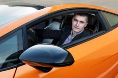 Homem de negócios novo feliz que conduz o carro desportivo luxuoso foto de stock royalty free Homem de negócios novo feliz que conduz o carro desportivo luxuoso foto de stock royalty free