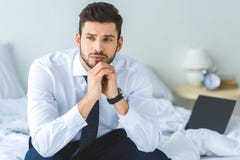 homem de negócios pensativo considerável no assento branco da camisa e do laço fotos de stock homem de negócios pensativo considerável no assento branco da camisa e do laço fotos de stock