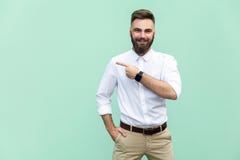Homem de negócios que aponta o espaço da cópia Homem adulto novo considerável com a barba na camisa branca que olha a câmera e ap Fotografia de Stock Homem de negócios que aponta o espaço da cópia Homem adulto novo considerável com a barba na camisa branca que olha a câmera e ap Fotografia de Stock