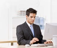 Homem de negócios que datilografa no computador fotografia de stock royalty free Homem de negócios que datilografa no computador fotografia de stock royalty free