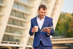 Homem de negócios que guarda a tabuleta e o copo imagens de stock royalty free Homem de negócios que guarda a tabuleta e o copo imagens de stock royalty free
