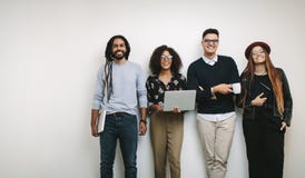 Homem de negócios que guarda um copo de café que está com os colegas de trabalho no offi imagem de stock royalty free Homem de negócios que guarda um copo de café que está com os colegas de trabalho no offi imagem de stock royalty free