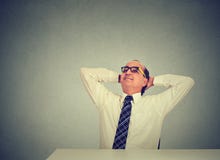 Homem de negócios que relaxa em sua mesa que olha acima imagens de stock Homem de negócios que relaxa em sua mesa que olha acima imagens de stock