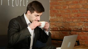 Homem de negócios que trabalha no portátil e no café bebendo no café vídeos de arquivo Homem de negócios que trabalha no portátil e no café bebendo no café vídeos de arquivo