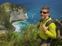 Homem desportivo feliz e atrativo novo do caminhante com a trouxa trekking que caminha no curso de apreciação livre do sentimento imagem de stock royalty free Homem desportivo feliz e atrativo novo do caminhante com a trouxa trekking que caminha no curso de apreciação livre do sentimento imagem de stock royalty free