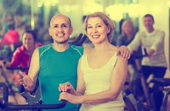 Homem e mulher que levantam em um gym e em um sorriso imagem de stock Homem e mulher que levantam em um gym e em um sorriso imagem de stock