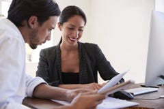 Homem e mulher que olham originais em um escritório, fim acima foto de stock royalty free Homem e mulher que olham originais em um escritório, fim acima foto de stock royalty free