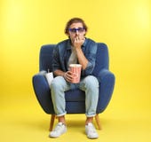 Homem emocional com os vidros 3D, a pipoca e a bebida sentando-se na poltrona durante a mostra do cinema foto de stock Homem emocional com os vidros 3D, a pipoca e a bebida sentando-se na poltrona durante a mostra do cinema foto de stock