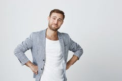 Homem europeu à moda considerável e seguro com a barba no revestimento com o corte de cabelo na moda que guarda as mãos nos quadr imagens de stock Homem europeu à moda considerável e seguro com a barba no revestimento com o corte de cabelo na moda que guarda as mãos nos quadr imagens de stock