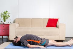 Homem farpado caucasiano bonito na roupa preta no yogamat azul imagem de stock Homem farpado caucasiano bonito na roupa preta no yogamat azul imagem de stock