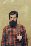 Homem farpado com a barba com coração rosado de matéria têxtil na camisa foto de stock royalty free Homem farpado com a barba com coração rosado de matéria têxtil na camisa foto de stock royalty free