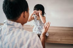Homem louco em sua filha ao trabalhar no escritório domiciliário imagem de stock Homem louco em sua filha ao trabalhar no escritório domiciliário imagem de stock