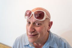 Homem mais idoso com os óculos de sol das mulheres do vintage, calvos, calvície, quimioterapia, câncer, no branco imagem de stock Homem mais idoso com os óculos de sol das mulheres do vintage, calvos, calvície, quimioterapia, câncer, no branco imagem de stock