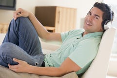 Homem na sala de visitas que escuta auscultadores fotos de stock Homem na sala de visitas que escuta auscultadores fotos de stock