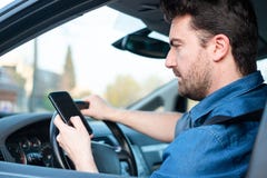 Homem no carro usando o telefone celular na roda fotos de stock royalty free Homem no carro usando o telefone celular na roda fotos de stock royalty free