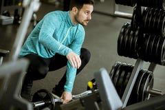 Homem novo considerável que prepara pesos no gym foto de stock Homem novo considerável que prepara pesos no gym foto de stock