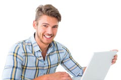 Homem novo considerável que senta-se usando o portátil imagens de stock Homem novo considerável que senta-se usando o portátil imagens de stock
