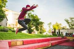 Homem novo freerun no corredor do parque público da cidade do verão, saltando e voando, conceito do parkour fotografia de stock royalty free Homem novo freerun no corredor do parque público da cidade do verão, saltando e voando, conceito do parkour fotografia de stock royalty free